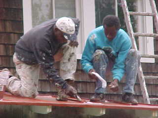 Two crew members performing work along drip edge