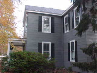 View of color scheme with charcoal siding, black roof and white trim