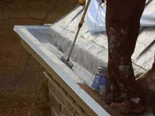 First step in gutter work is brushing down primer by a Roof Menders' crew member