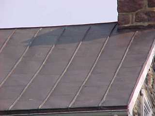 Closeup of roof panels with tin roof paint in bronze color